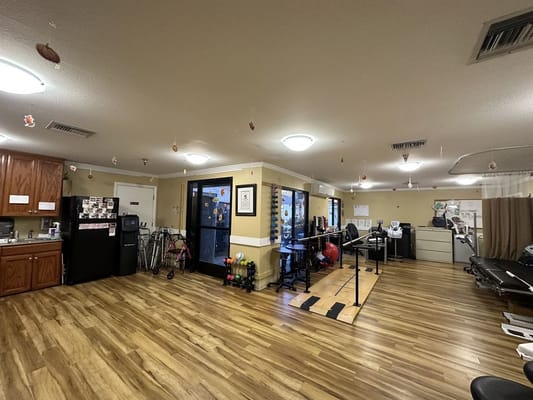 Interior view of gym area with exercise equipment and kitchen space.