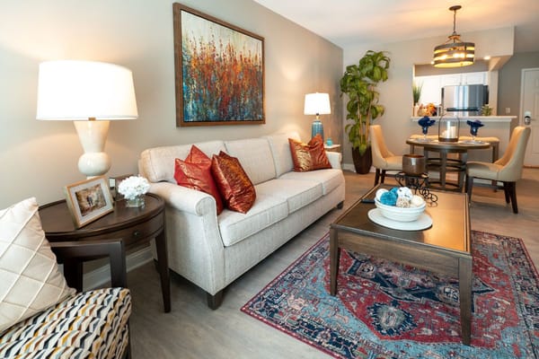 Living room with a beige sofa, decorative pillows, and dining area