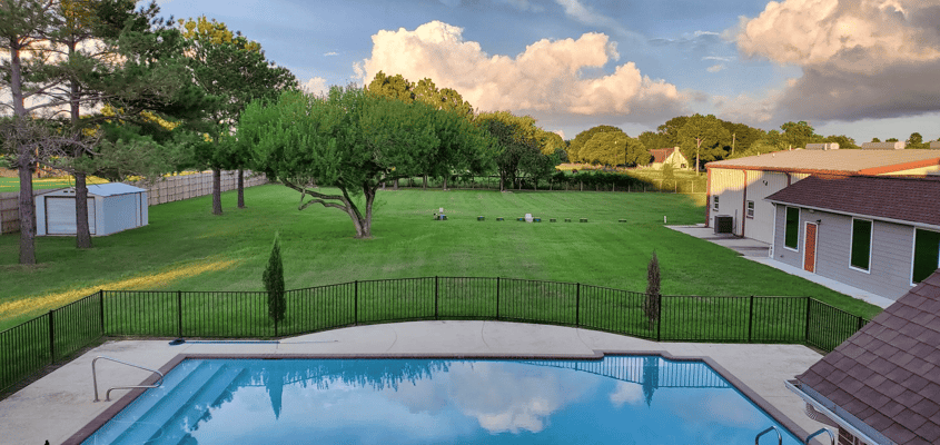 Exterior view of a grassy area and swimming pool
