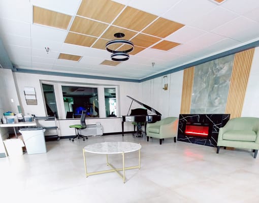 Bright interior common area with seating and a piano