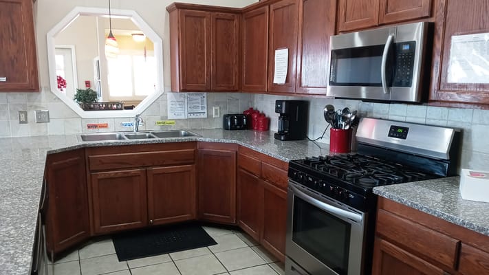 Interior view of a facility kitchen with cabinets and appliances.
