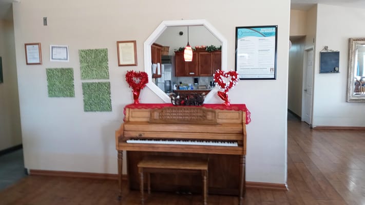 Piano in a decorated common area with holiday decor