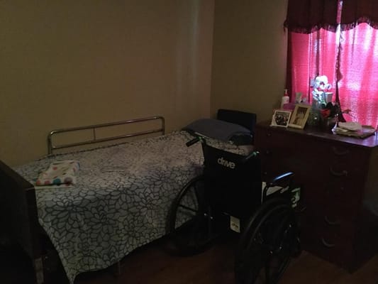 A private resident room with a bed and wheelchair