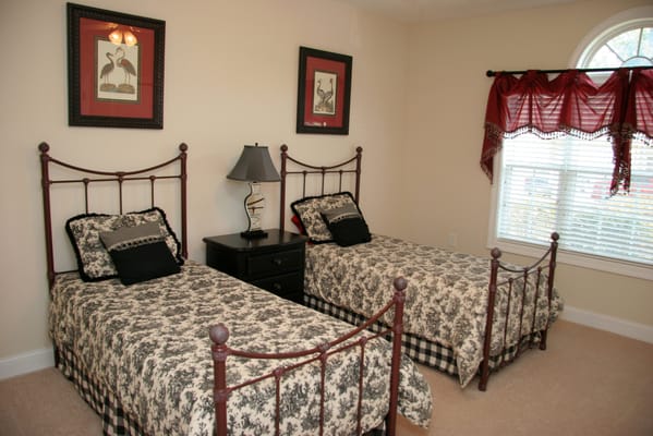 Two twin beds with floral bedding in a bright room.