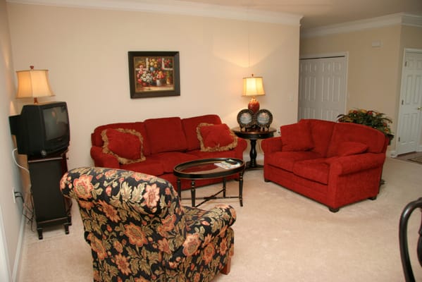 Comfortable living room with red sofas and floral armchair