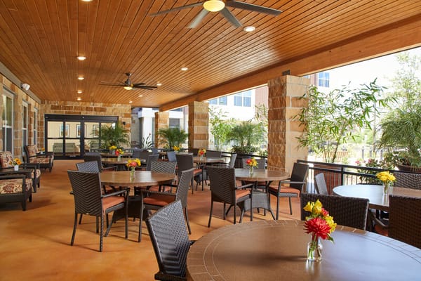 Covered outdoor lounge area with tables and flowers