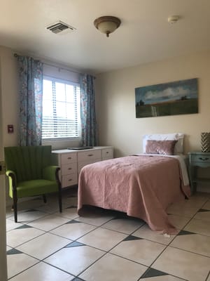 Private resident room with bed and chair