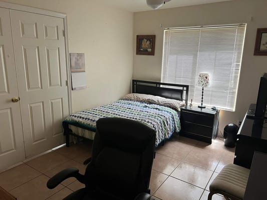 Cozy bedroom with a bed, chair, and window.