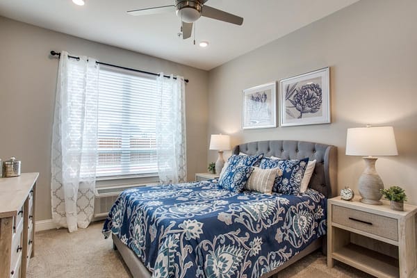 A cozy resident bedroom with floral decor and natural light