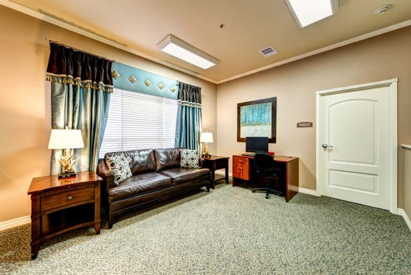 Living room with a sofa, desk, and curtains