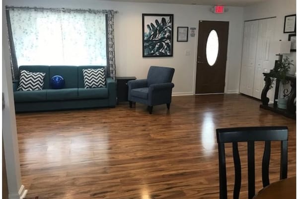 Spacious living room with green couch and blue exercise ball.