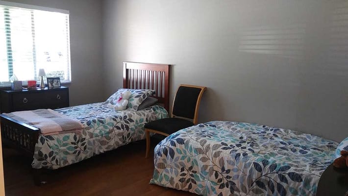 Simple twin bedroom setup in a care facility