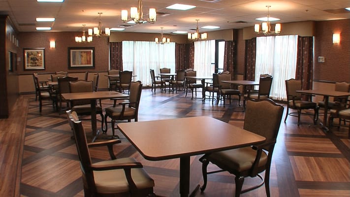 Dining room with tables and chairs set up for residents
