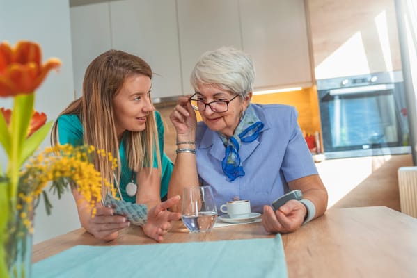 A caregiver and resident sharing a conversation at a table