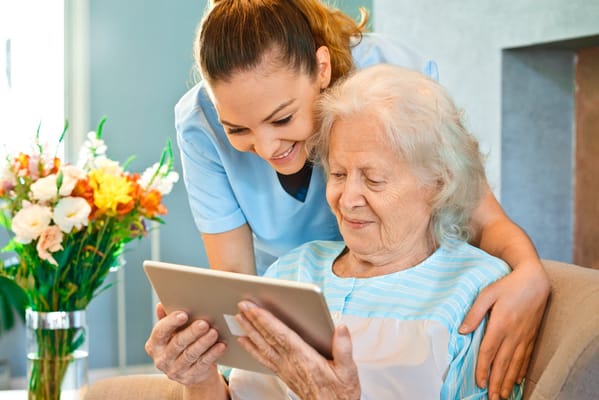 Staff member and resident enjoying time together with a tablet