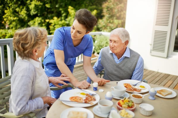Outdoor dining with staff and residents enjoying breakfast