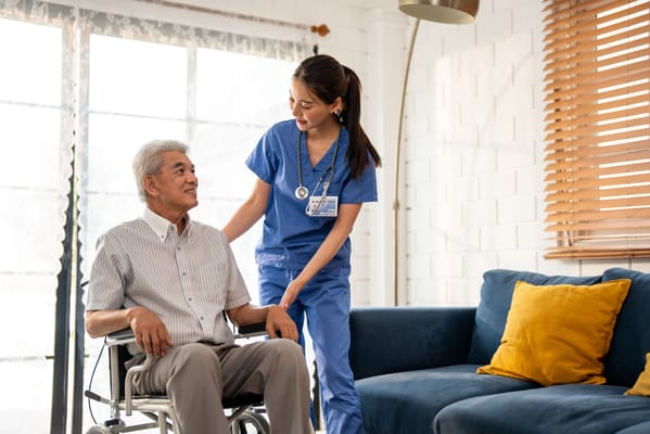 A caregiver assisting a senior resident in a cozy living area