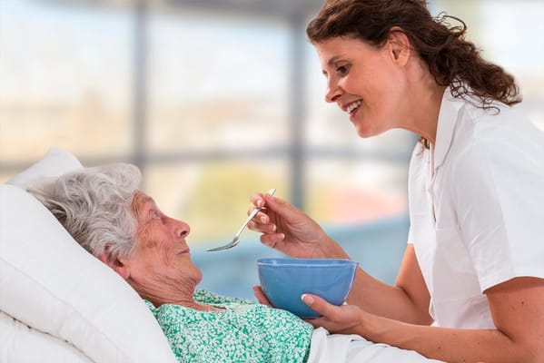 Caregiver feeding a resident in a care facility