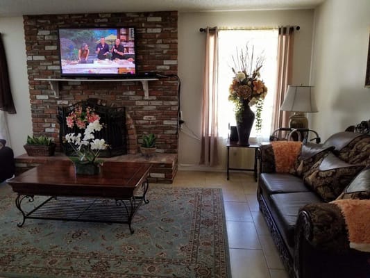 Cozy interior common area with a fireplace and TV