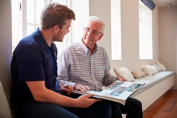 A caregiver sharing a photo book with a senior resident