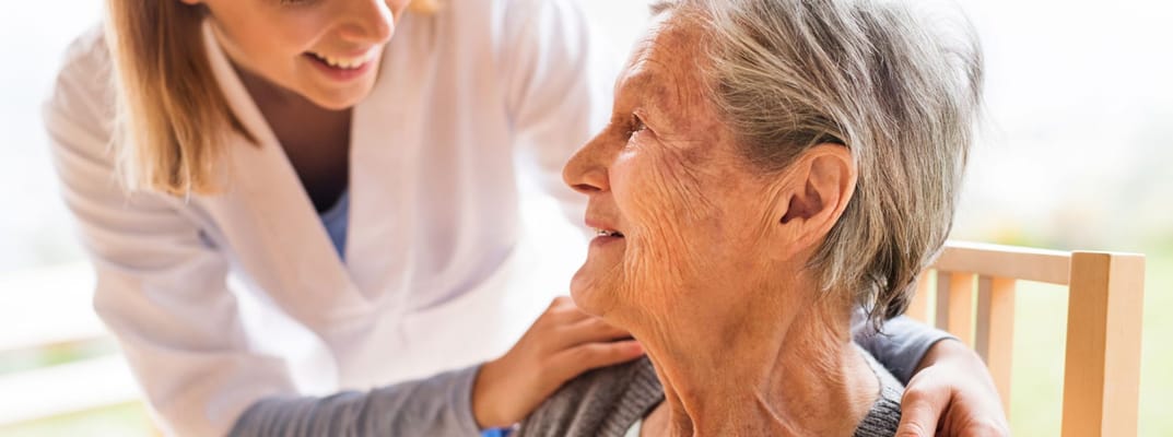 Caregiver smiling at an elderly resident