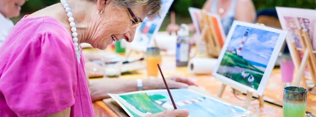 Resident painting outdoors with art supplies