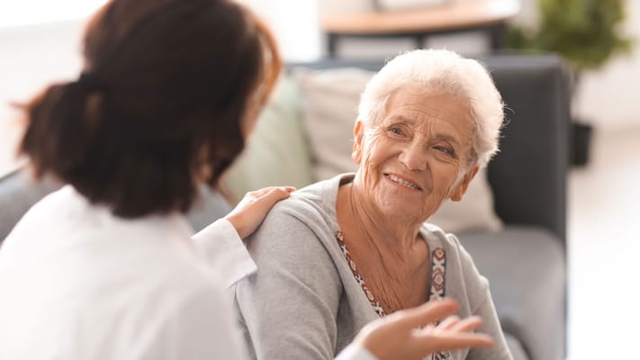 Resident interacting with staff in a bright lounge