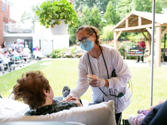 A caregiver interacting with a resident outdoors