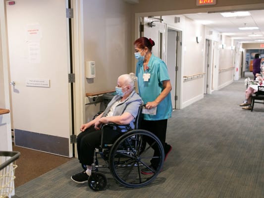 Staff member assisting a resident in a hallway