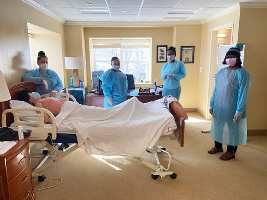 Healthcare staff attending to a patient in a room