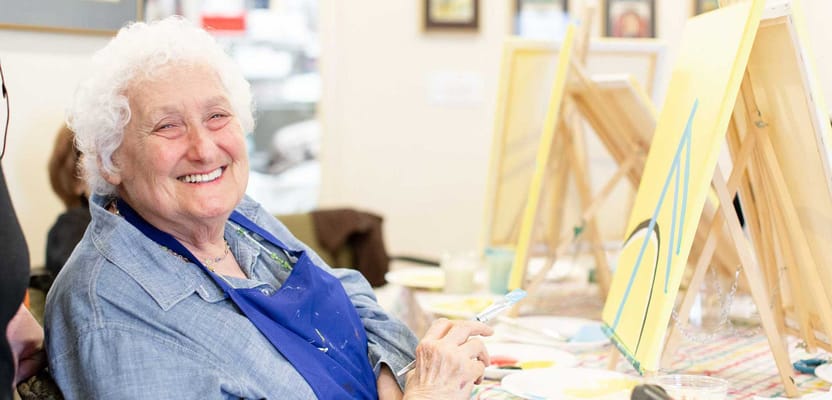 Resident painting in a bright interior space