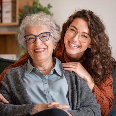 A resident and staff member smiling together in a cozy setting