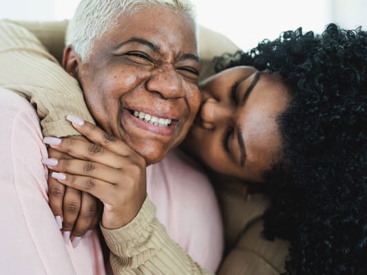 A joyful embrace between two women, showing affection.