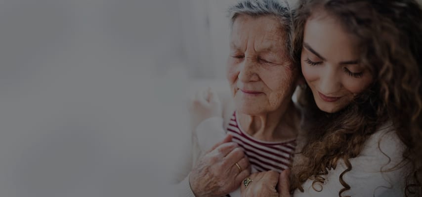 A caregiver embracing an elderly resident warmly