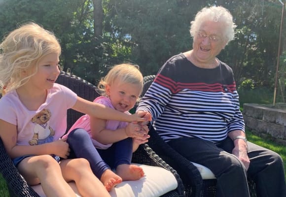 Elderly woman enjoying time with young children outdoors