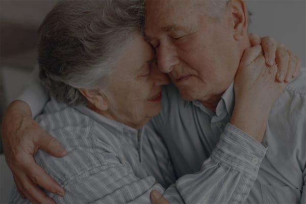 Elderly couple embracing each other warmly