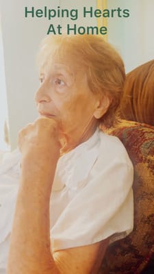 An elderly woman in a thoughtful pose in a cozy setting