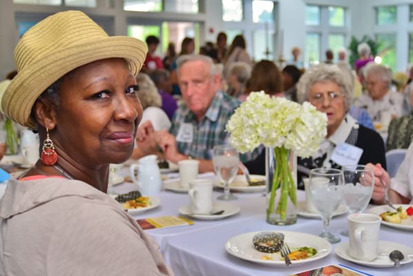 Residents enjoying a meal and conversation at a dining table