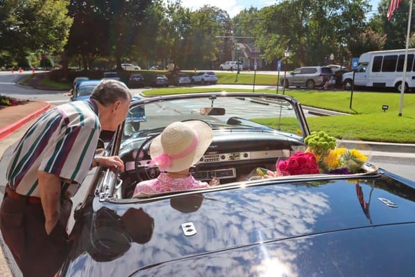 Senior residents enjoying a ride in a convertible car