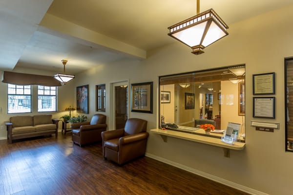 A cozy lobby area with seating and reception desk at Goldware Senior Housing.