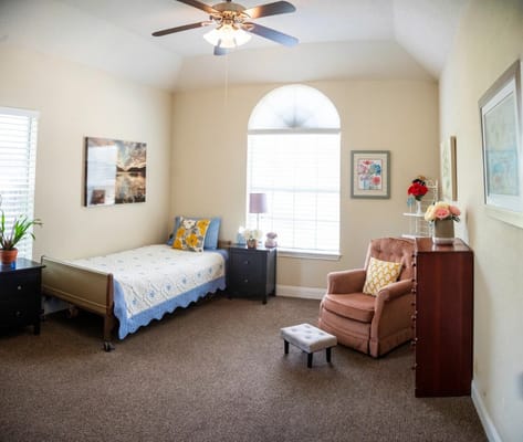 Cozy private resident room with a bed and chair