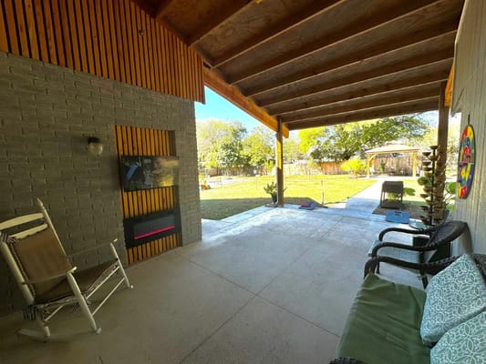 Covered patio area with seating and green space