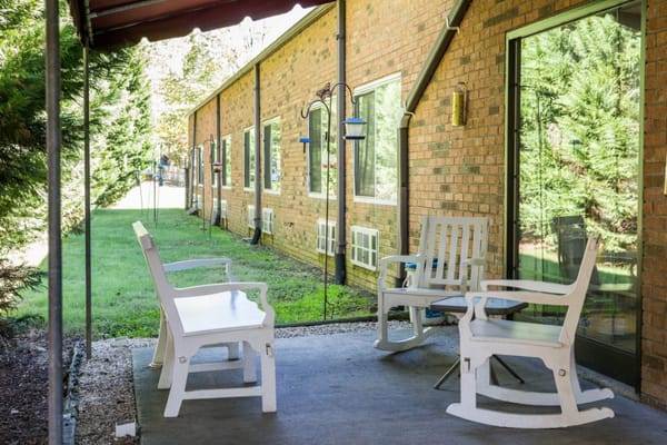 Outdoor seating area with rocking chairs and greenery