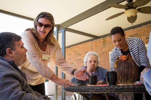 Staff engaging with residents at an outdoor table