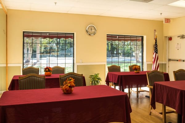 Bright common area with tables and floral arrangements