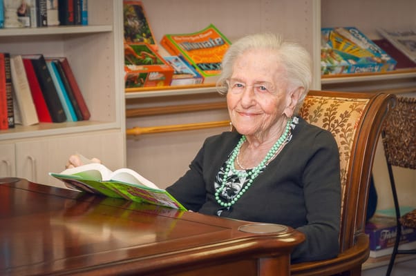 Elderly resident reading a book in a cozy interior