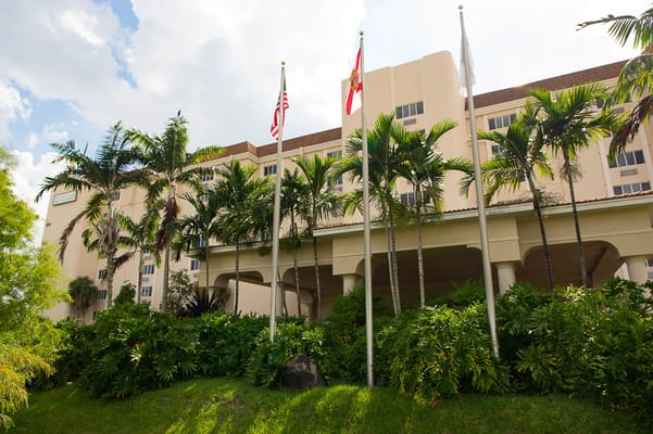 Exterior view of the facility with flags and palm trees