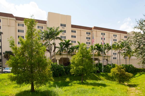 Exterior view of Life Care Center at Inverrary amidst greenery