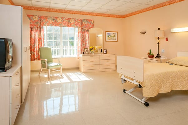Bright interior of a resident room with a bed and seating area
