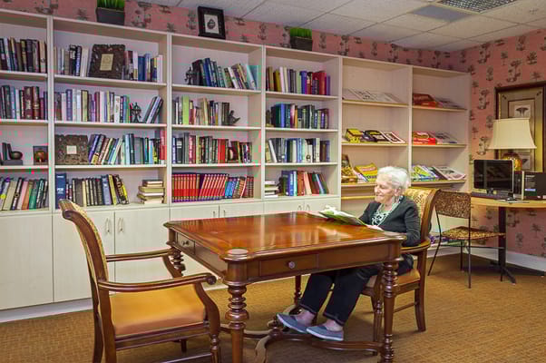 Senior resident reading in a cozy library area